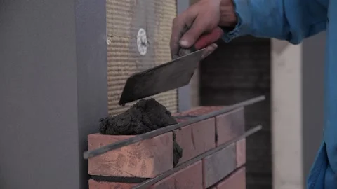 Construction worker levels wall with spatula.man worker lays cement and bricks Stock Footage 163967457