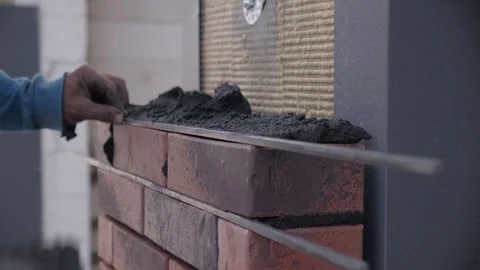 Construction worker levels wall with spatula.man worker lays cement and bricks Stock Footage 163967480