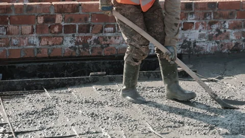 Construction worker levels wet concrete using shovel during slab formation on Video stock 306404839