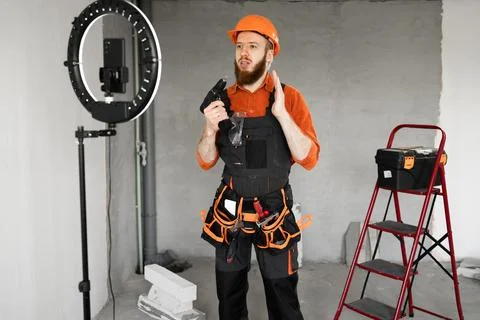 Construction Worker Live Streaming Home Renovation Tutorial for Social Media. Stock Photos