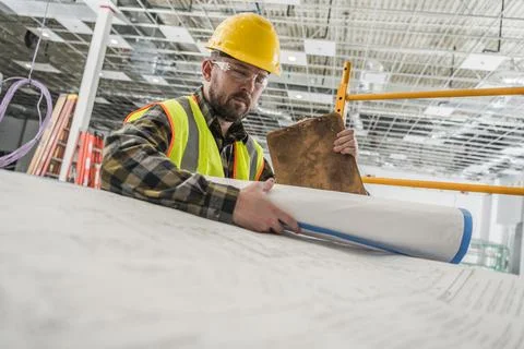 Construction Worker Looking Inside Building Blueprints Stock Photos