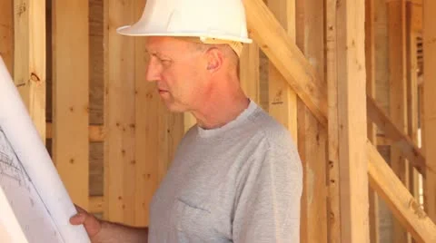 Construction worker looking over blueprints. Видео 11821498