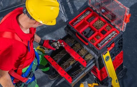 Construction Worker Looking For a Right Screw For His Job Photos