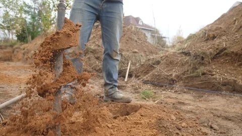 A construction worker makes a hole in the ground Stock Footage 319402707