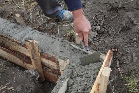 Construction worker making concrete foundation in formwork Fotos Stock