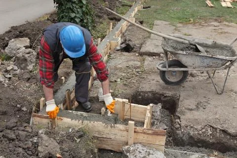Construction worker making concrete foundation in formwork 库存照片