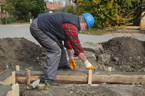 Construction worker making concrete foundation in formwork Фото