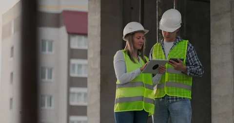 Construction worker man and architect woman in a helmet, discuss the plan of Video stock 112334863