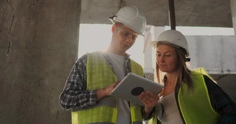 Construction worker man and architect woman in a helmet, discuss the plan of 스톡 동영상 112336444