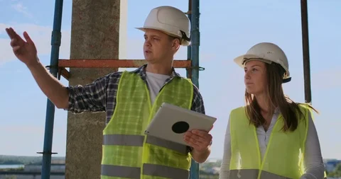 Construction worker man and architect woman in a helmet, discuss the plan of Video stock 113150806