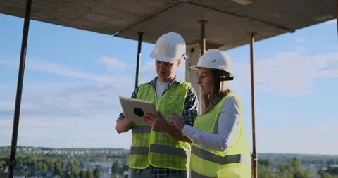 Construction worker man and architect woman in a helmet, discuss the plan of Video stock 113151751