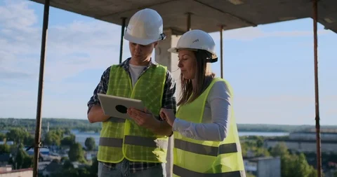 Construction worker man and architect woman in a helmet, discuss the plan of Video stock 113151902