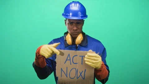 Construction worker man holding cardboard sign reading act now and points f.. Stock Footage 339133291