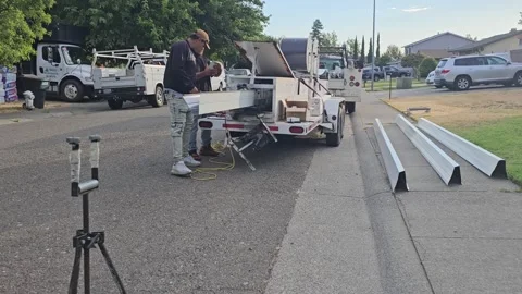 Construction worker manufacturing new rain gutters, extruding new gutter Stock Footage 247781893