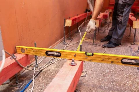 Construction worker measures distance between  wooden blocks on the studs fo Stock Photos