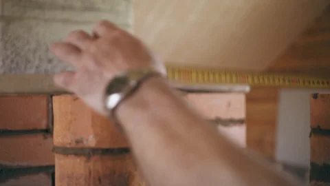 Construction worker is measuring a brick wall with a roulette Stock Footage 90135575