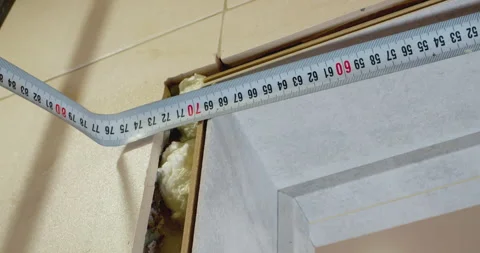 Construction worker measuring door frame with tape measure Stock Footage 306856139