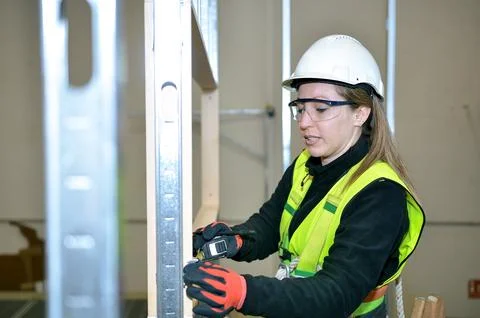 Construction worker measuring plasterboard with laser distance meter Stock Photos