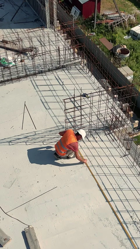 Construction worker measuring rebar framework on building structure. A Stock Footage 319839394