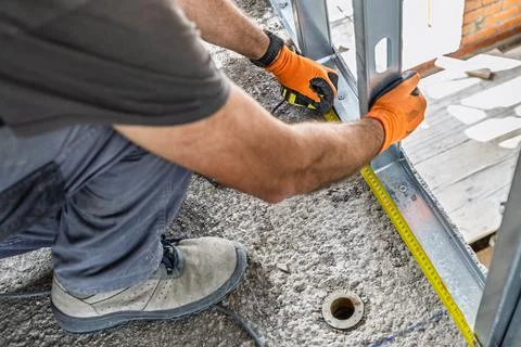 Construction worker measuring steel frame on building site Stock Photos
