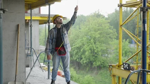 Construction worker measuring with tape on building site Stock-Footage 337466998