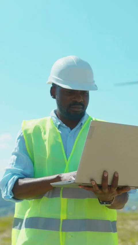 A construction worker meticulously reviewing and analyzing plans outdoors under Stock Footage 314206469