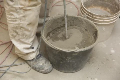 The construction worker mixes tile adhesive together with the water in the corre 写真素材