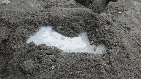 A construction worker mixing cement and sand using a hoe Stock Footage 307557577