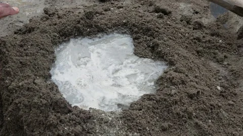 A construction worker mixing cement and sand using a hoe Stock Footage 307557788