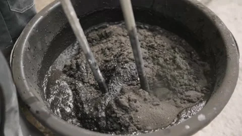 Construction worker mixing cement in a bucket Stock-Footage 312118923