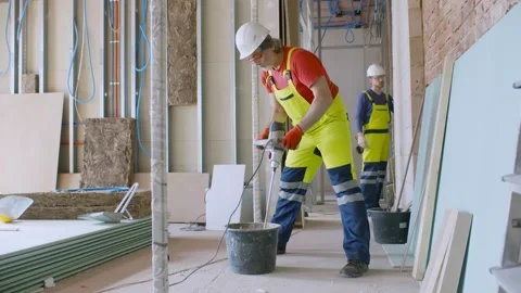 Construction worker mixing cement with electric mixer indoors Stock Footage 133639654