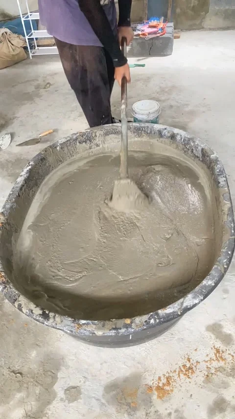 Construction worker mixing cement mortar with shovel at building site. Video stock 332566378