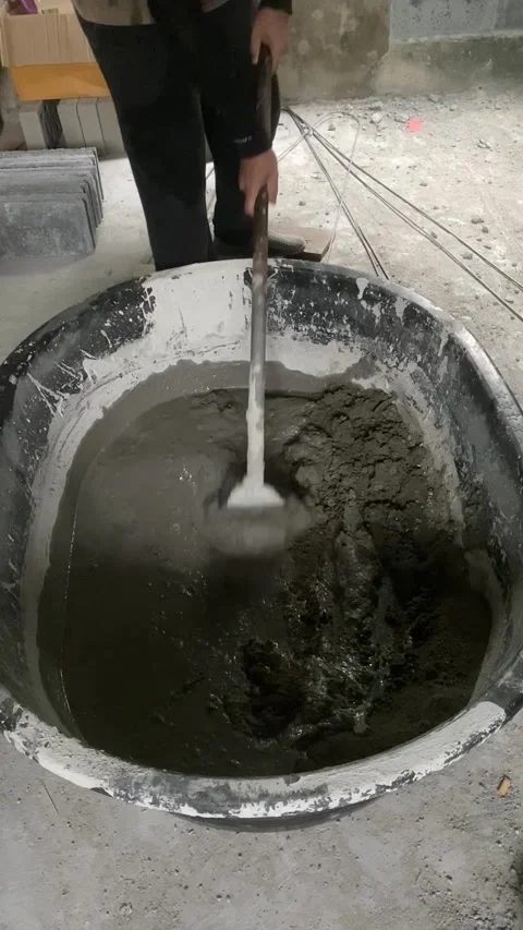 Construction worker mixing cement mortar with shovel at building site. Video stock 332566437