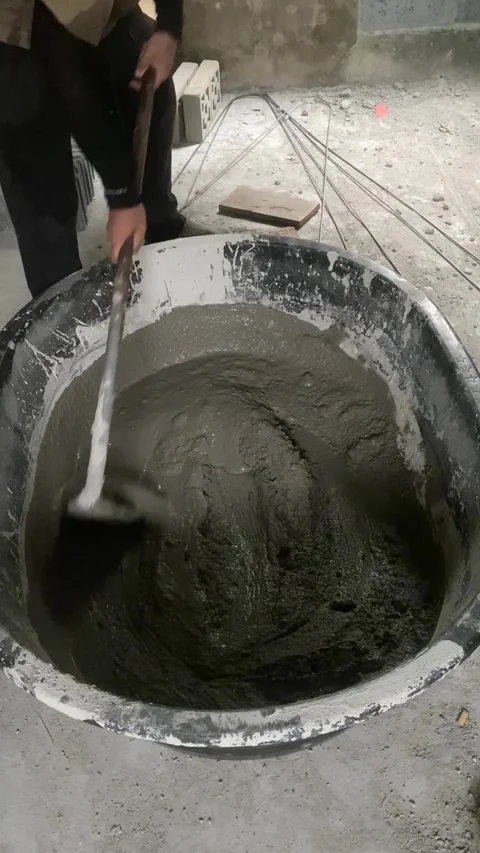 Construction worker mixing cement mortar with shovel at building site. Video stock 332566442