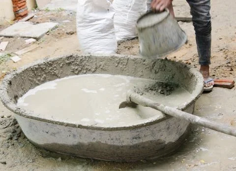Construction worker mixing cement mortar plaster for interior walls Stock Photos