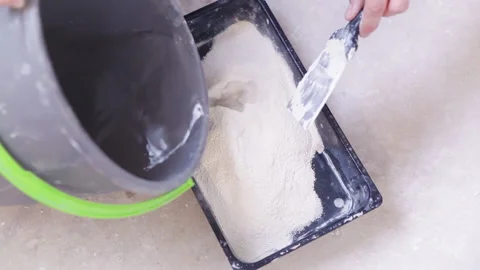Construction worker mixing dry mixture with water to make alabaster Stock-Footage 157920683