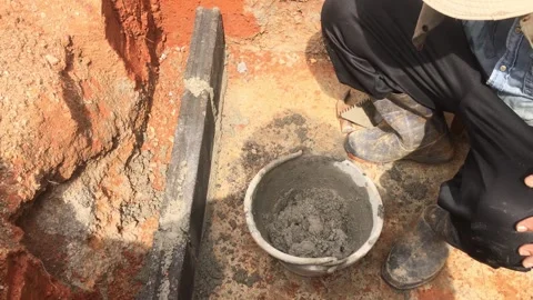 Construction worker mixing mortar and laying bricks to build Stock Footage 346218018