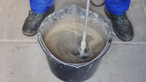 Construction worker mixing mortar in a bucket Stockbeeldmateriaal 275409963
