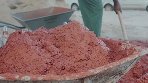 Construction worker mixing wattle and daub mixture in a wheelbarrow Stock Footage 341301989