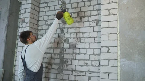 Construction worker moisturing brick wall with water sprayer Stock Footage 102166827