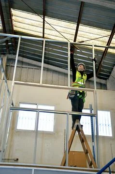 Construction worker mounting metal frame for plasterboard ceiling Stock Photos