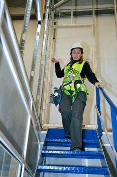 Construction worker mounting plasterboard on metal frame structure Stock Photos