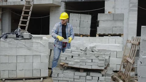 Construction worker moving concrete cinder blocks Video stock 337466328