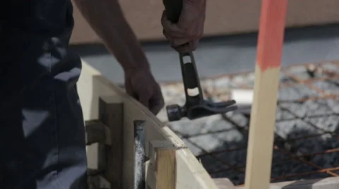 Construction worker nailing a plank with a hammer Stock Footage 63916940