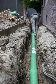 Construction worker, newly laid green sewage pipe, trench, Stuttgart, Stock Photos