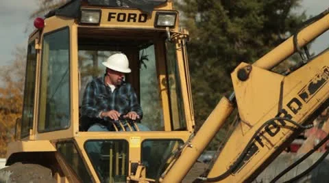 Construction worker operates backhoe 스톡 동영상 21562803