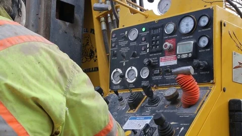 Construction worker operates well drilling controls rear Stock Footage 77278390