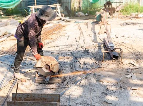 A construction worker is operating an abrasive chop saw or fiber cutting ma.. Stock Photos