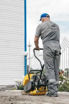 Construction Worker Operating Compactor on Building Site Stock Photos