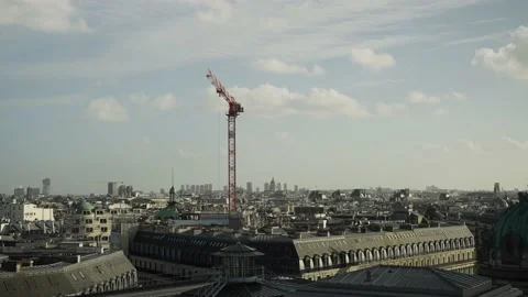 Construction worker operating crane above city buildings in Paris Europe Stock Footage 170785469